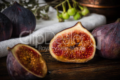 Half ripe and juicy fig lying on rustic table