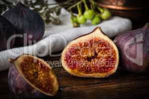 Half ripe and juicy fig lying on rustic table