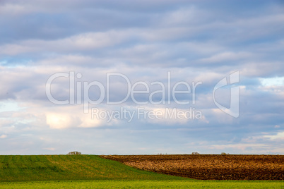 Landscape with plowed field and blue sky.