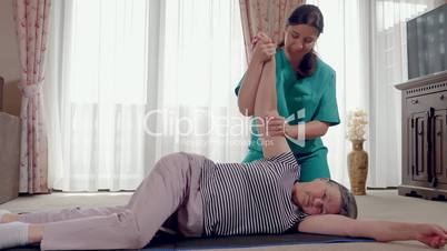 Senior during rehabilitation with physiotherapist after an arm injury