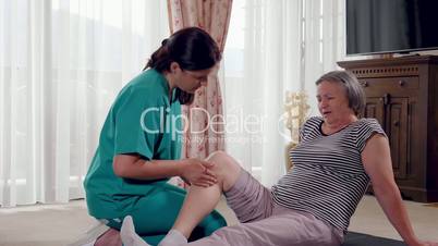 Elderly lady being rehabilitated by a physiotherapist at home