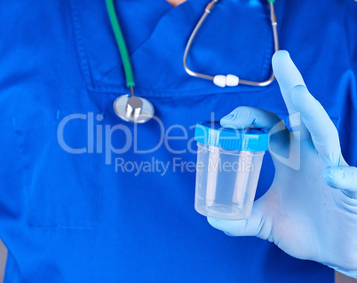 the doctor in blue uniform and latex gloves is holding an empty