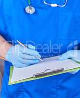 doctor in blue uniform holds a pen and paper holder