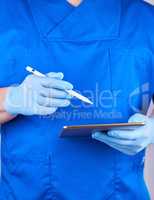 doctor in blue uniform and latex gloves holding an electronic ta