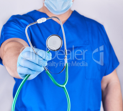 doctor in blue uniform and latex gloves holding a stethoscope