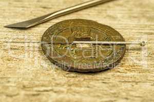 acupuncture needle on antique Chinese coin