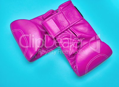 pair of pink leather boxing gloves on a blue background