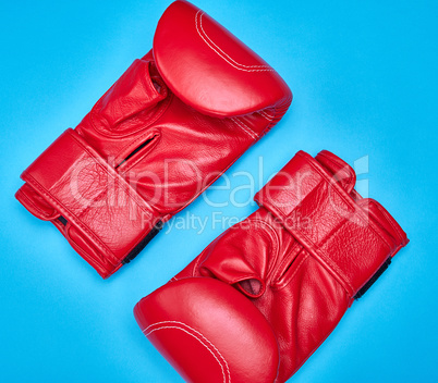 pair of red leather boxing gloves on a blue background