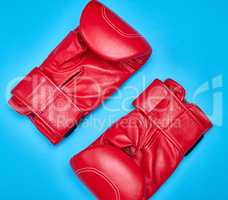 pair of red leather boxing gloves on a blue background