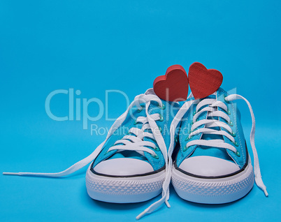 pair of blue textile sneakers with white untied laces