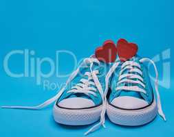 pair of blue textile sneakers with white untied laces