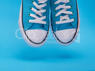 pair of blue textile sneakers with white laces