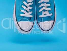 pair of blue textile sneakers with white laces