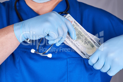 male doctor puts a wad of dollars in his shirt pocket, concept o