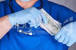 male doctor puts a wad of dollars in his shirt pocket, concept o