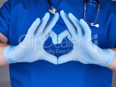 doctor in blue uniform and old latex gloves showing heart gestur