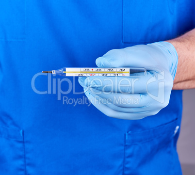doctor with blue latex gloves and uniform holding a glass mercur