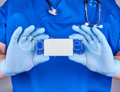 male doctor wearing blue latex gloves is holding a empty  white