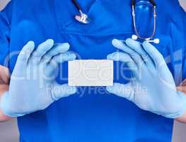 male doctor wearing blue latex gloves is holding a empty  white