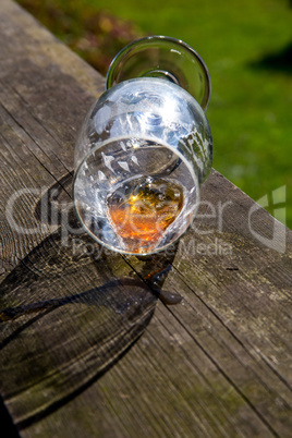 Overturned glass of beer on wooden table.