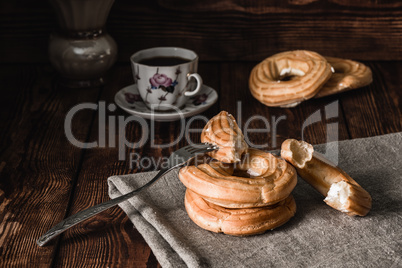 Stacked Eclairs with fork and cup on the table