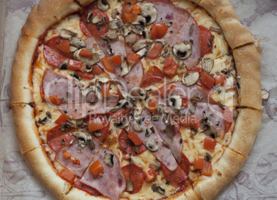 Italian fast food. Delicious hot pizza sliced and served on wooden platter with ingredients, close up view. Menu photo