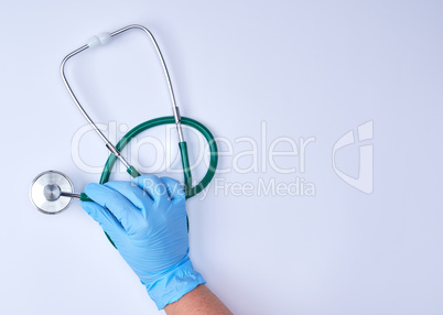 human hand in blue latex sterile gloves holding a medical stetho