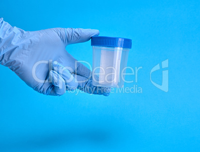 hand in latex sterile gloves holding a empty plastic jar for me