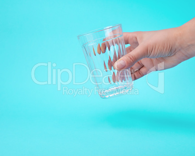 woman's hand holding an empty transparent glass