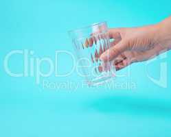 woman's hand holding an empty transparent glass