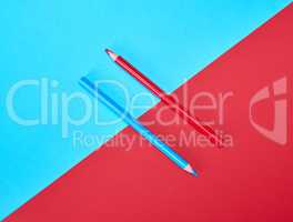 red and blue wooden pencils on color abstract background