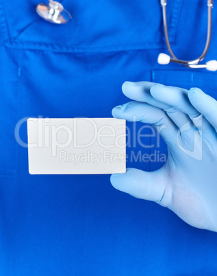 male doctor wearing blue latex gloves is holding a blank white p