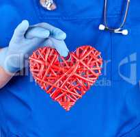 doctor in blue uniform  holds a big red heart