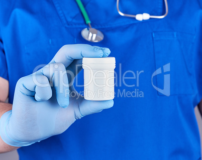 doctor in blue uniform and sterile latex gloves holds plastic pi