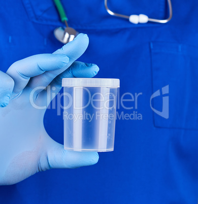 doctor in blue uniform and latex gloves is holding an empty plas