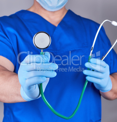 doctor in blue uniform and sterile gloves holding a medical stet