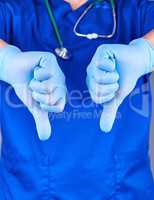 doctor in blue uniform and latex sterile gloves shows a gesture