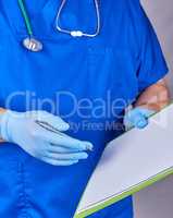 doctor in blue uniform holds a pen and paper holder in his hand