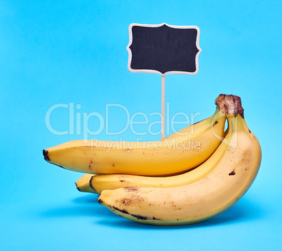 ripe yellow bananas and wooden signpost with empty black space