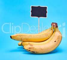 ripe yellow bananas and wooden signpost with empty black space