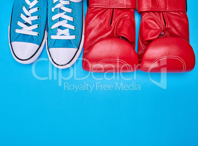 pair of red boxing gloves and blue textile sneakers