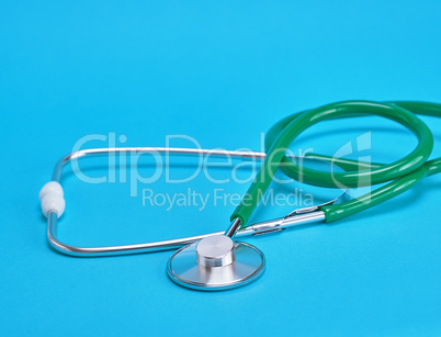 green medical stethoscope on blue background