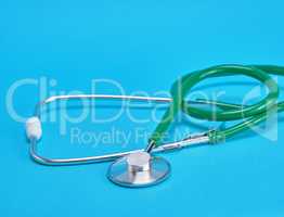 green medical stethoscope on blue background