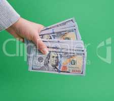 hand holding paper money on a green background