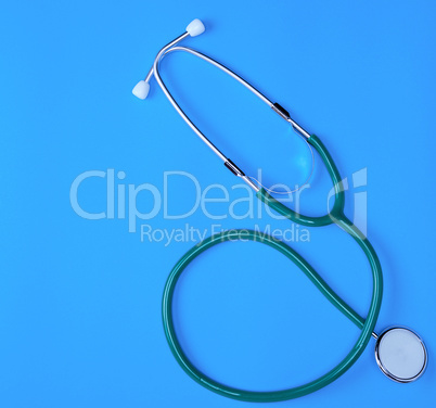 green medical stethoscope on blue background