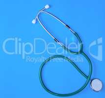 green medical stethoscope on blue background