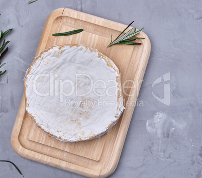 round brie cheese on a wooden cutting board