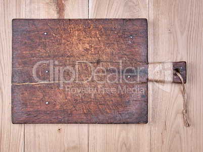 very old brown square cutting board with a handle