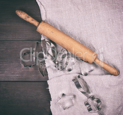 wooden rolling pin and iron bakeware on a brown wooden table