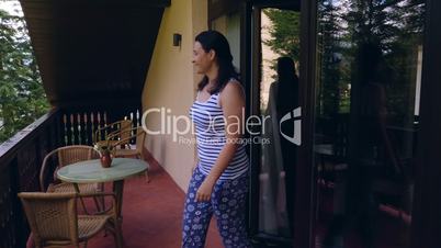 Young woman coming on terrace to relax in the morning